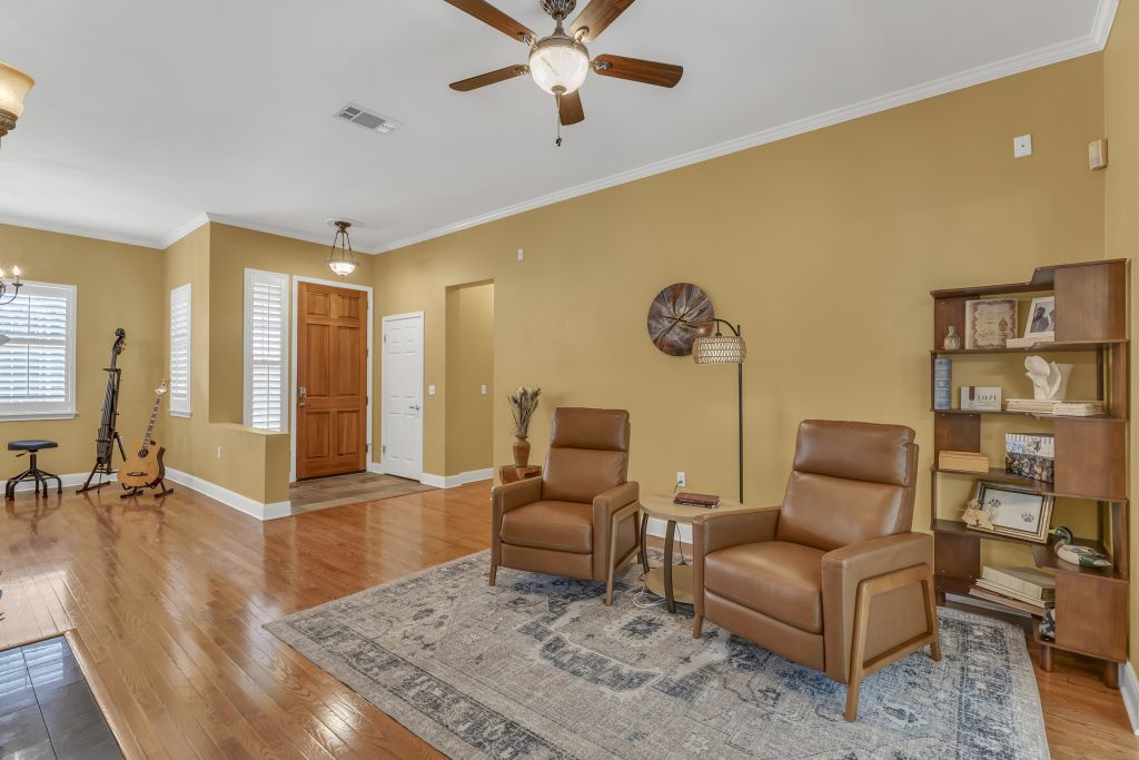 144 Cattle Trail Way Georgetown, TX 78633 - Photo 4 of 37 Natural light illuminates this inviting living space, showcasing rich hardwood floors and crown molding.