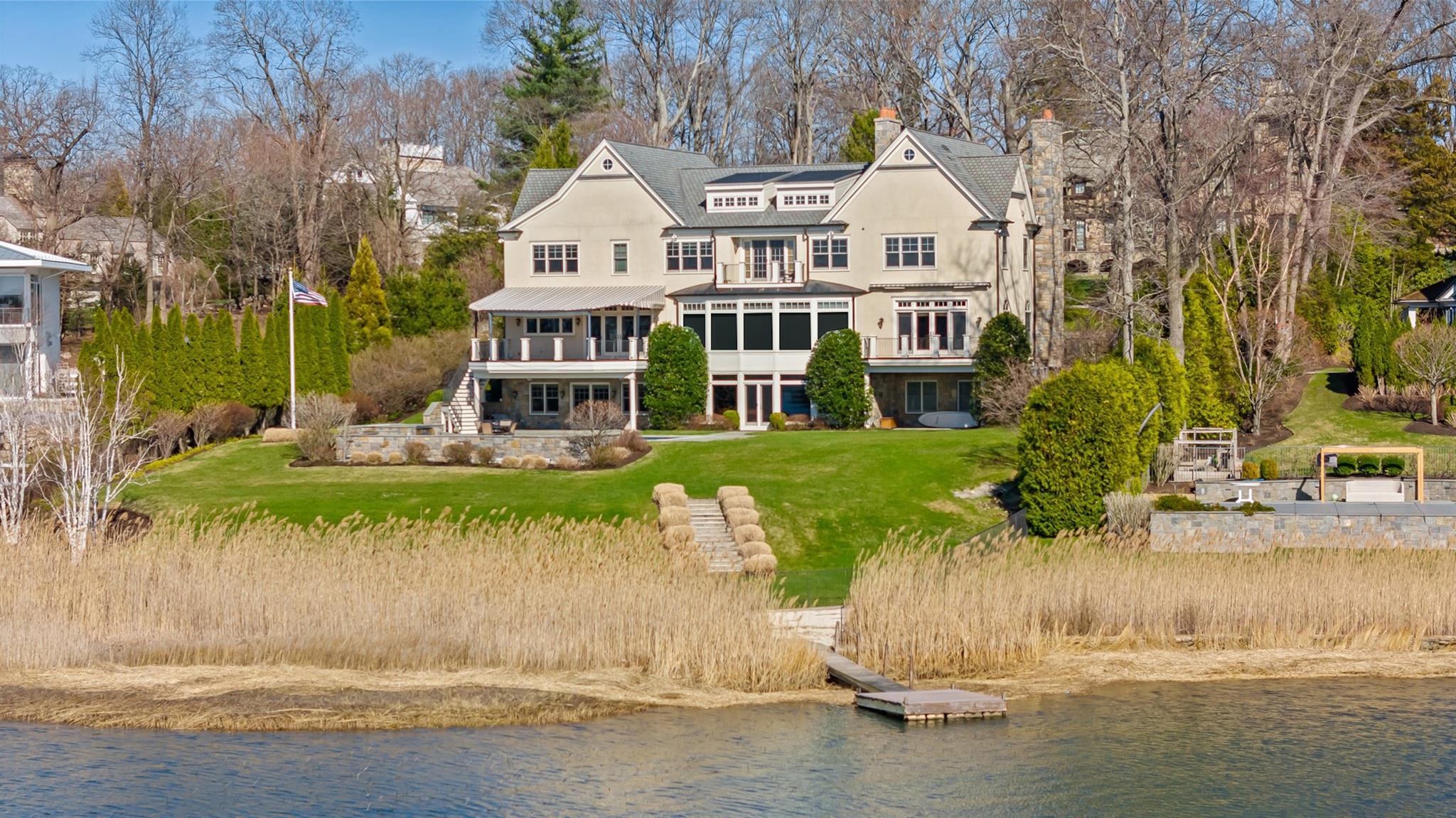 a front view of a house with a yard and lake view