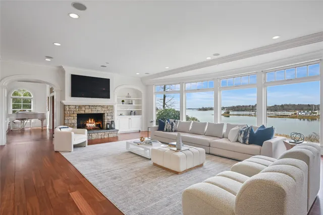 a living room with furniture fireplace and a large window