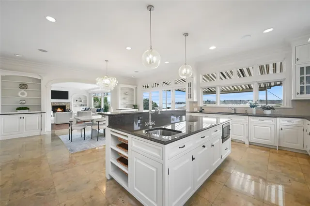 a kitchen with stainless steel appliances granite countertop a stove and a view of living room