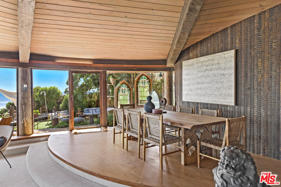 33604 Pacific Coast Highway Malibu, CA 90265 - Photo 12 of 46 a dining room with furniture large windows and wooden floor