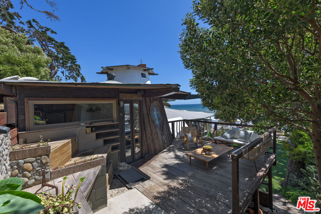 33604 Pacific Coast Highway Malibu, CA 90265 - Photo 24 of 46 a view of a patio with table and chairs with wooden fence and plants