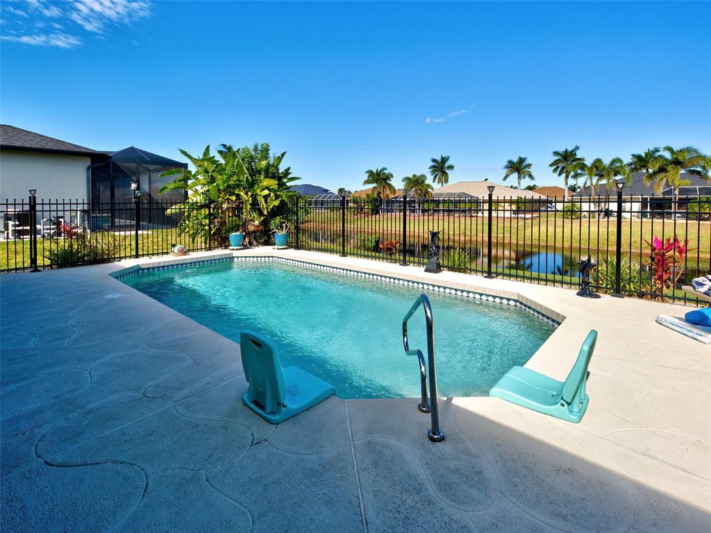 77 Medalist Road Rotonda West, FL 33947 - Photo 2 of 81 a swimming pool with outdoor seating and yard