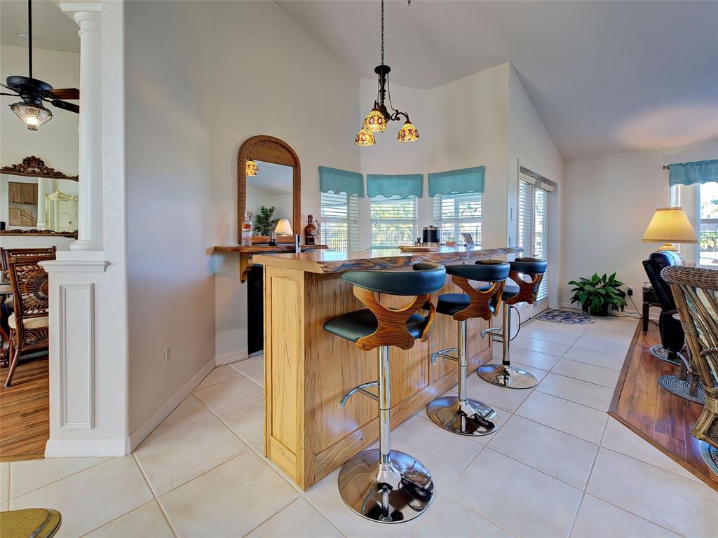 77 Medalist Road Rotonda West, FL 33947 - Photo 24 of 81 a view of a dining room with furniture one side kitchen view chandelier