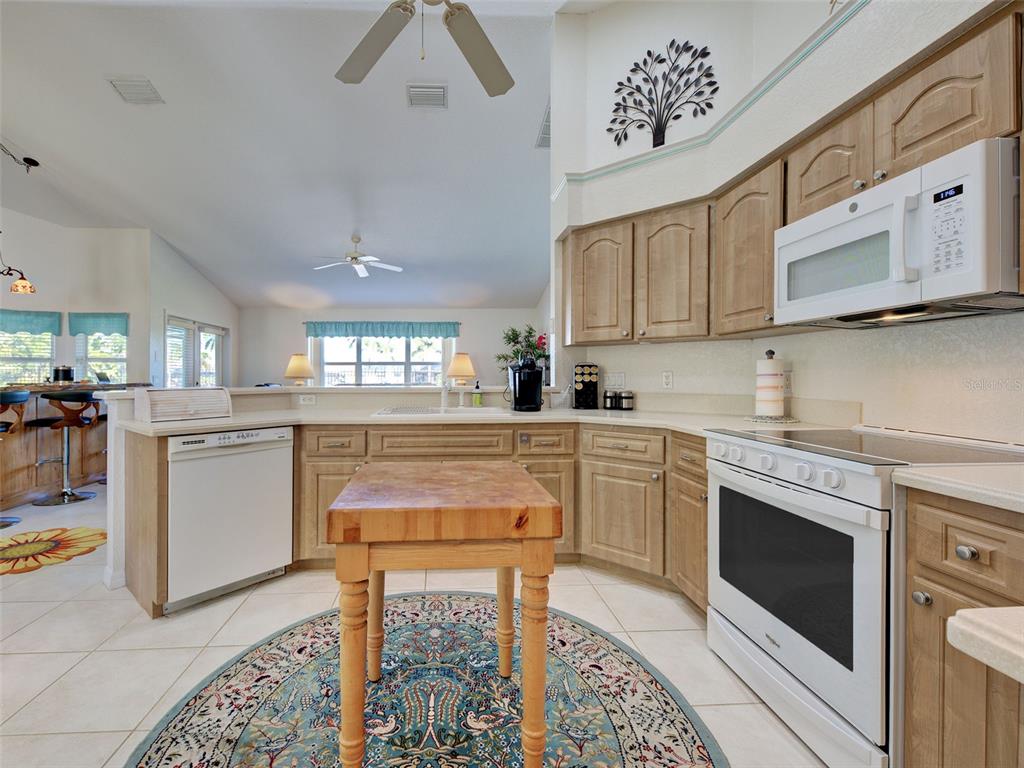 77 Medalist Road Rotonda West, FL 33947 - Photo 30 of 81 a kitchen with granite countertop white cabinets and white appliances
