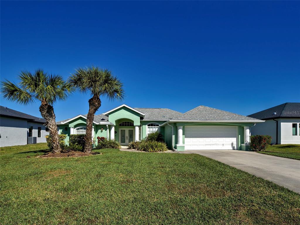 77 Medalist Road Rotonda West, FL 33947 - Photo 4 of 81 a front view of a house with a garden