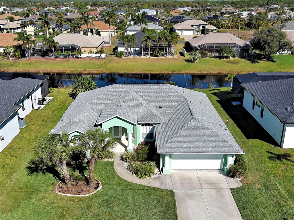 77 Medalist Road Rotonda West, FL 33947 - Photo 5 of 81 an aerial view of a house with a swimming pool yard and lake view