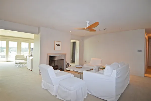 a living room with furniture a fireplace and a floor to ceiling window