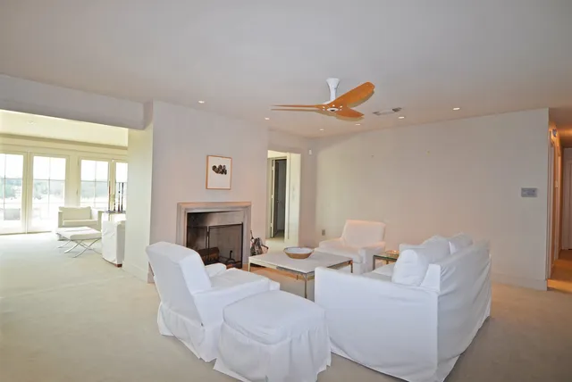 a living room with furniture a fireplace and a floor to ceiling window
