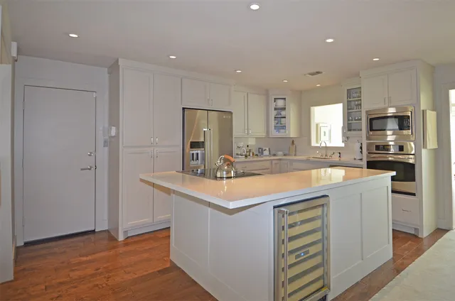 a kitchen with stainless steel appliances granite countertop a sink and a refrigerator