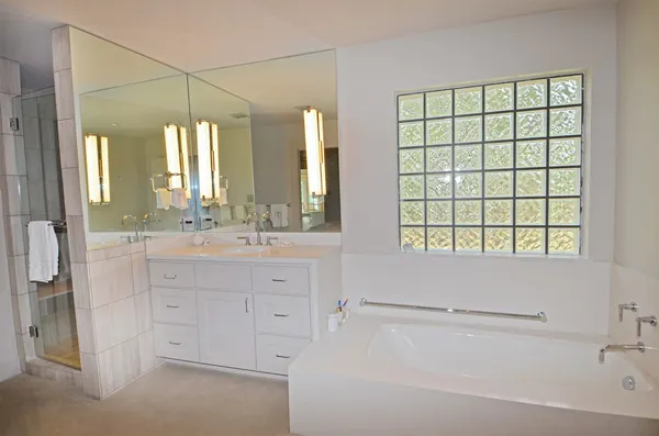 a bathroom with a double vanity sink window and a bathtub