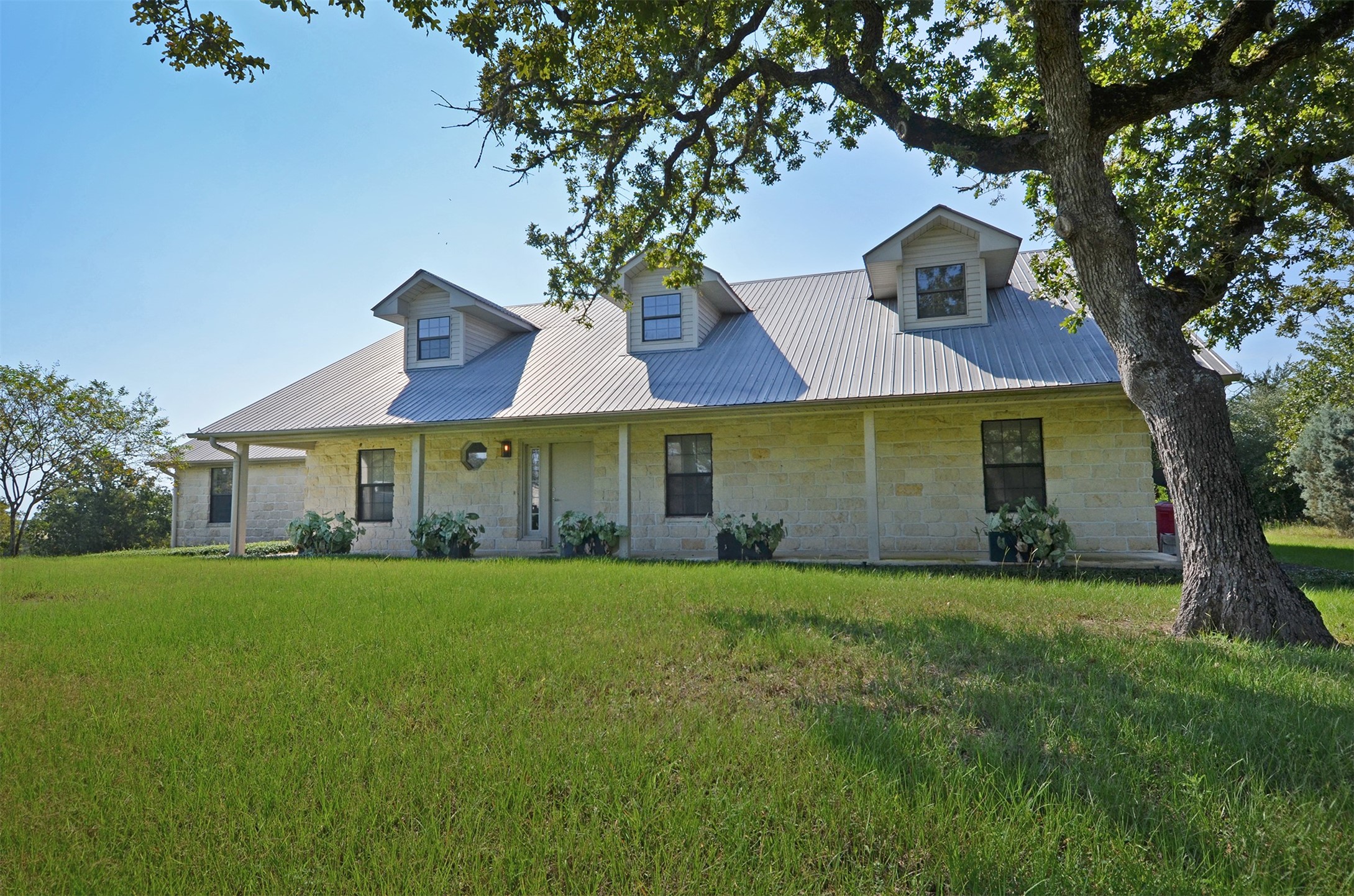1880 Schoenberg Road Carmine, TX 78932 - Photo 2 of 36 a view of a white house with a big yard and large trees