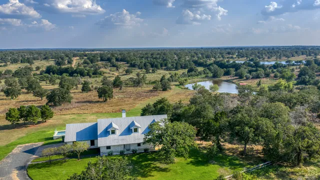 an aerial view of a house with a yard and lake view