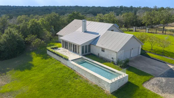 a view of a house with pool and a yard