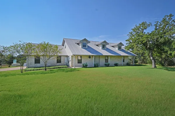 a front view of house with yard and trees