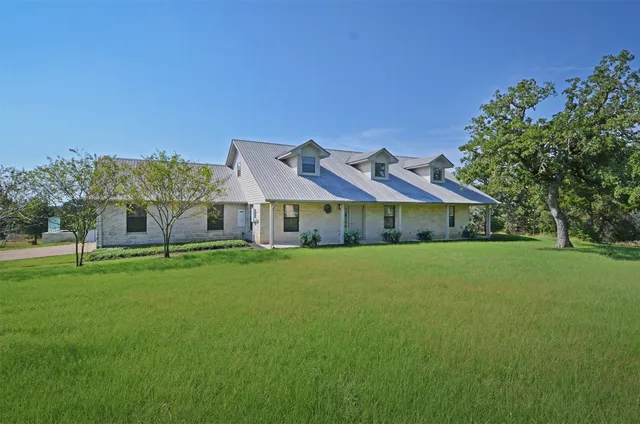 a front view of house with yard and trees