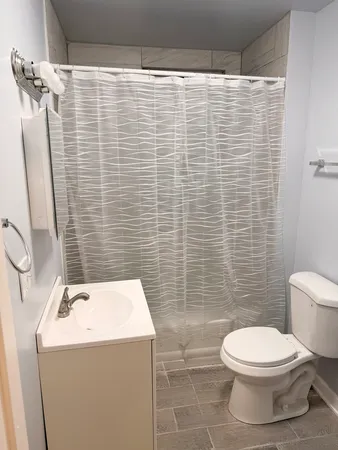 a bathroom with a sink a toilet and shower curtain