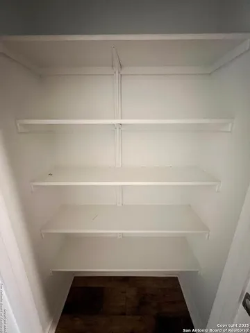 a view of walk in closet with empty racks