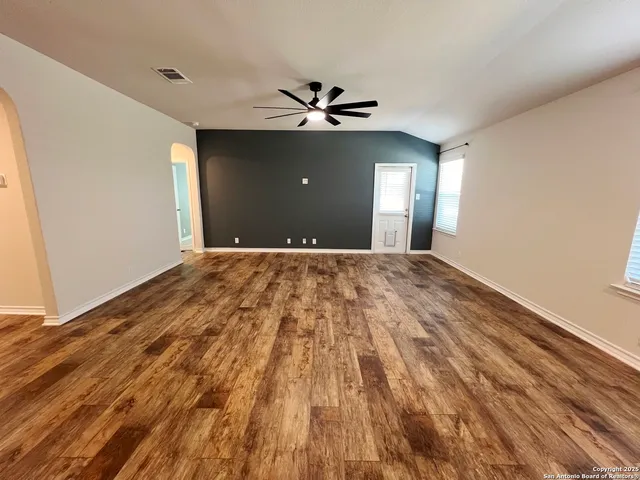 a view of a big room with wooden floor and windows in a room