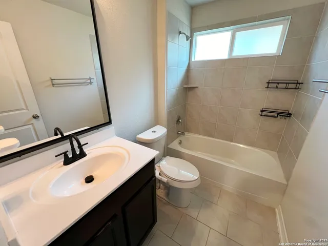 a bathroom with a sink a toilet a mirror and shower