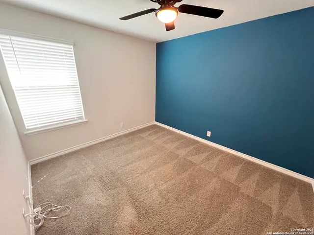 an empty room with windows and fan