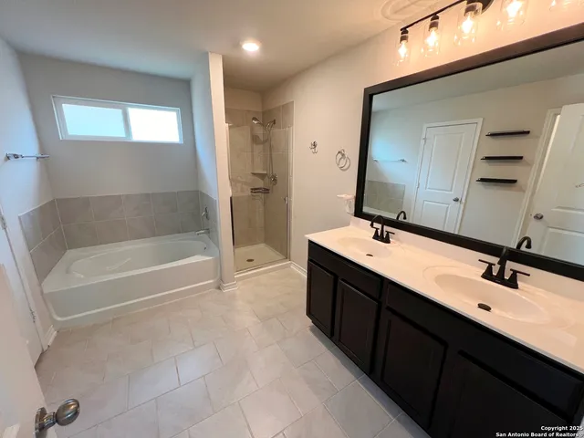 a bathroom with a double vanity sink mirror and bathtub