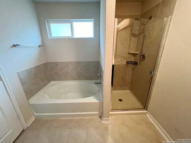 a white bath tub sitting next to a shower
