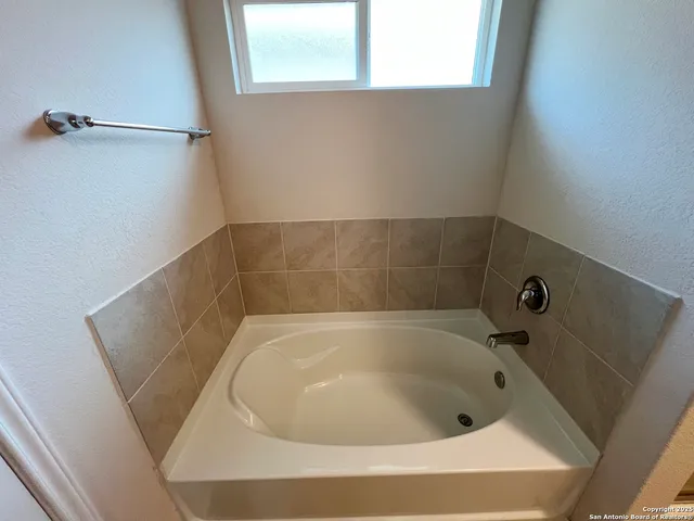 a bath tub sitting in a bathroom next to a window