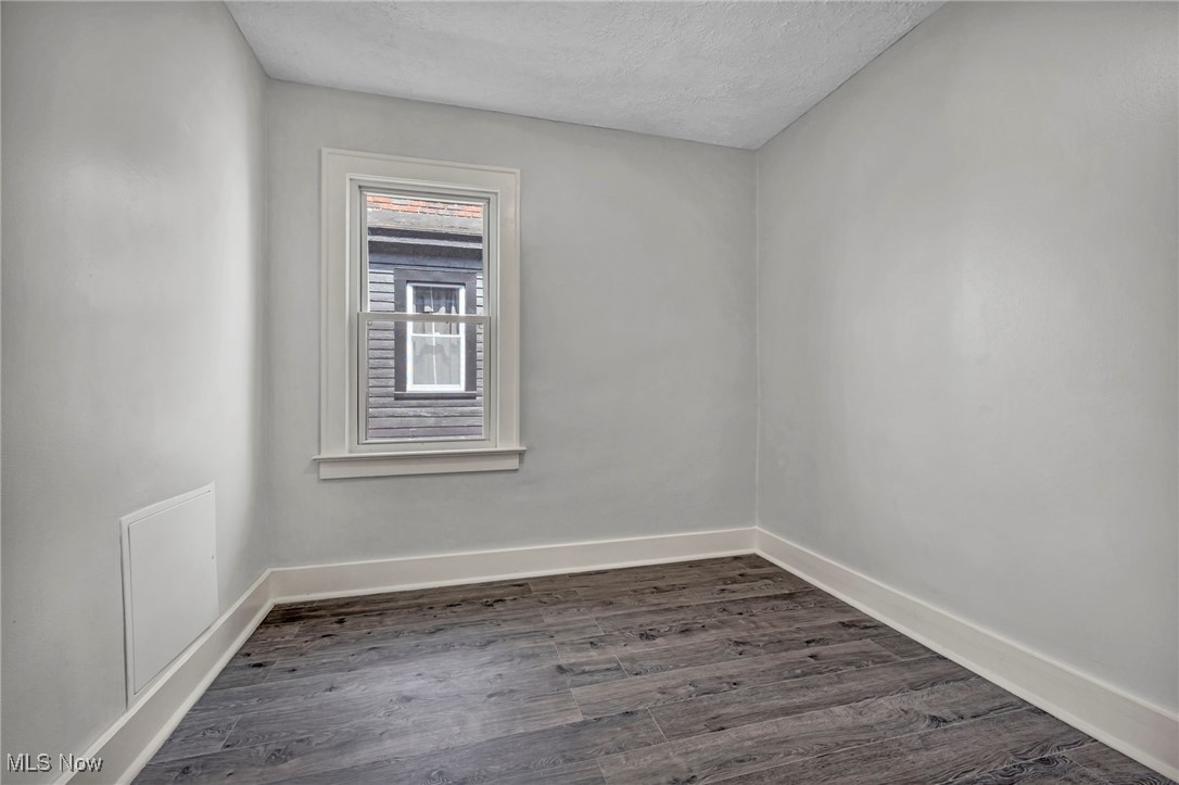 3239 Sycamore Road Cleveland, OH 44118 - Photo 17 of 49 Spare room featuring a textured ceiling, baseboards, and dark wood-type flooring