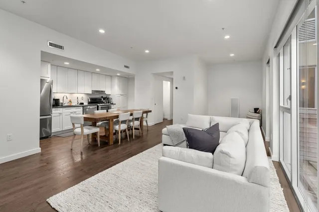 a living room with stainless steel appliances kitchen island furniture and a table
