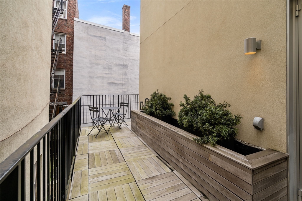126 Salem Street, Unit 3 Boston, MA 02113 - Photo 17 of 22 a balcony with wooden floor and potted plants