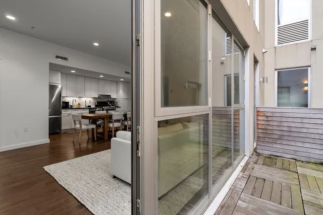 a kitchen with stainless steel appliances kitchen island granite countertop a refrigerator a stove and white cabinets with wooden floor