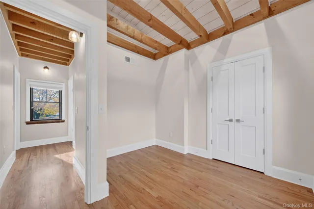 a view of a hallway with wooden floor and stairs
