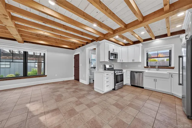 a kitchen with a sink window and stainless steel appliances