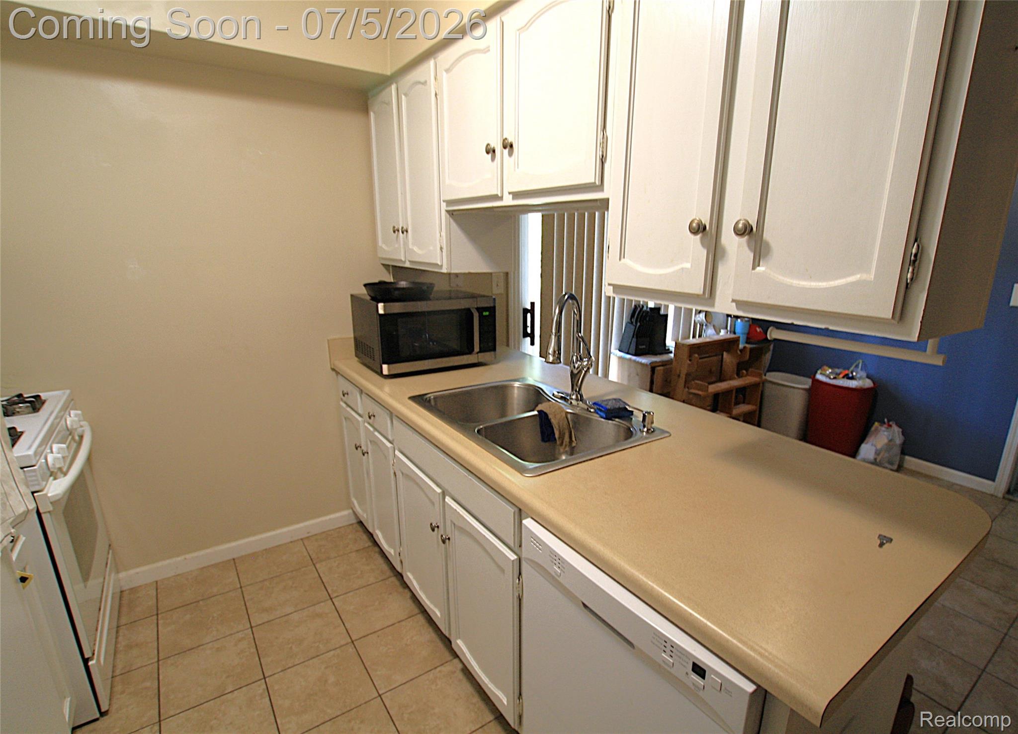 12403 Willard Road Montrose, MI 48457 - Photo 14 of 30 Kitchen with white cabinets, white appliances, light countertops, and light tile patterned floors