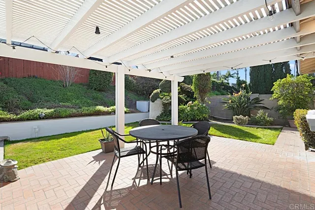 a view of a patio with a table and chairs under an umbrella