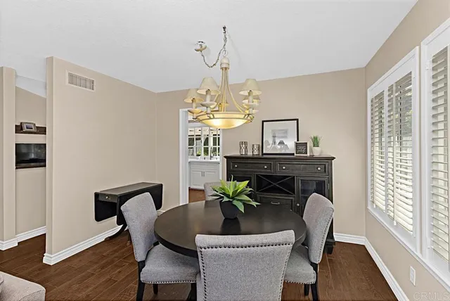 a dining room with furniture a chandelier and wooden floor