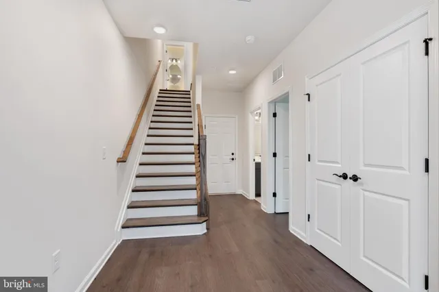 a view of a hallway with wooden floor and entryway