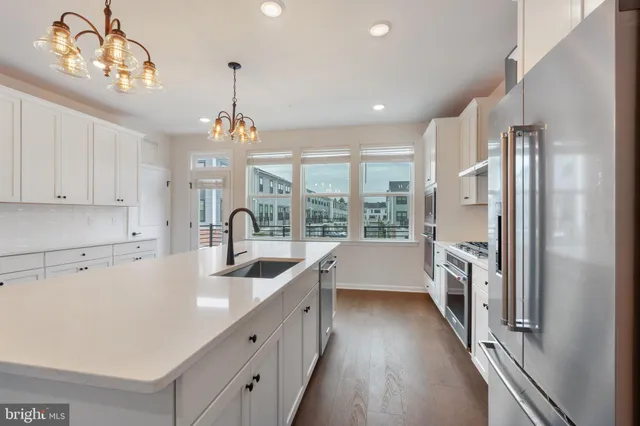 a kitchen with stainless steel appliances white cabinets and a stove top oven