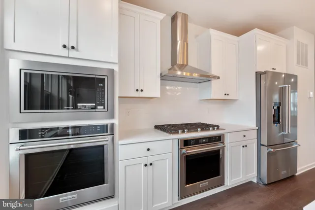 a kitchen with stainless steel appliances granite countertop a sink a stove and a wooden floors