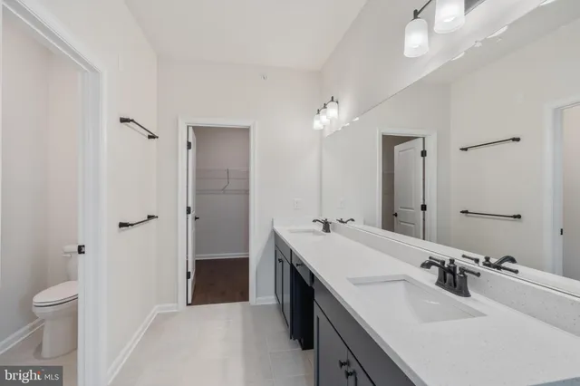 a bathroom with a sink double vanity granite tub shower and a mirror