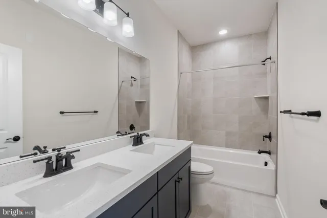 a bathroom with a double vanity sink toilet tub and shower