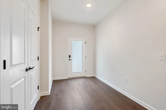 a view of a room with wooden floor and white doors
