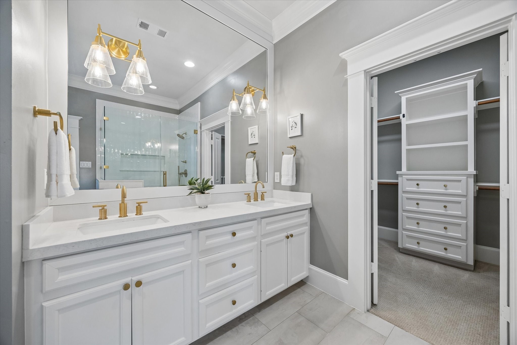 621 West 15th Street Houston, TX 77008 - Photo 22 of 37 Dual sinks with quartz countertops, stylish lighting, and a peek into the walk-in closet with built-ins.