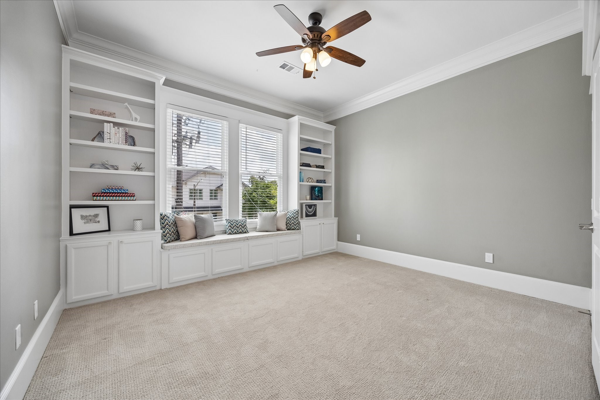 621 West 15th Street Houston, TX 77008 - Photo 28 of 37 Spacious secondary bedroom with built in shelving, darling window seat, crown molding, ceiling fan and closet.