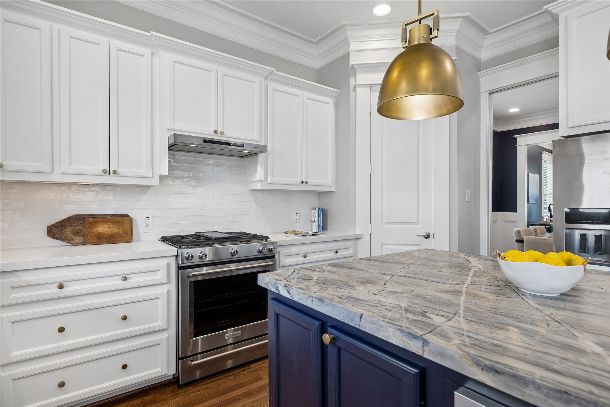 621 West 15th Street Houston, TX 77008 - Photo 8 of 37 The chef’s kitchen features a spacious island topped with a stunning Ijen Blue quartzite countertop, statement pendant lighting, and a stainless-steel convection oven with gas range and range hood.