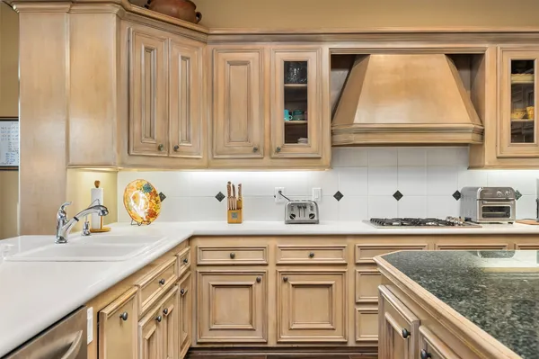 a kitchen with stainless steel appliances granite countertop a sink and a white cabinets