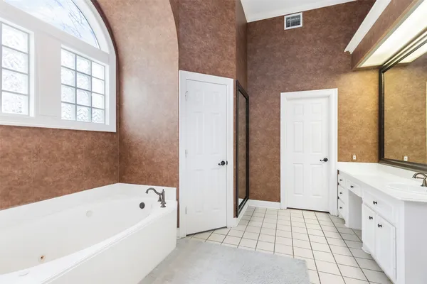 a bathroom with a bathtub a mirror a vanity and a shower