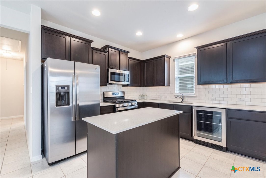 360 Spiny Lizard Lane San Marcos, TX 78666 - Photo 7 of 22 a kitchen with a sink a refrigerator a microwave and cabinets