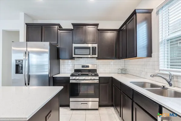 a kitchen with a sink and stainless steel appliances